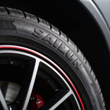 Side-profile close-up of Sailun tire sidewall lettering, crisp embossed branding on black rubber, dramatic lighting