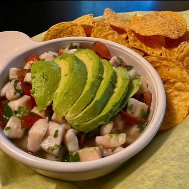 Ceviche served with lime, avocado and herbs