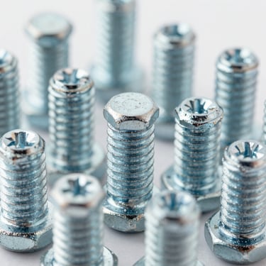 Macro shot of cold-forged steel socket head cap screws, clean thread profiles, industrial studio lighting, metallic steel tones, sharp details