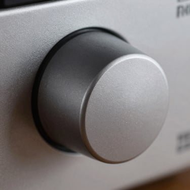 Extreme macro close-up of a matte-finish kitchen appliance dial, technical precision, cool warehouse lighting