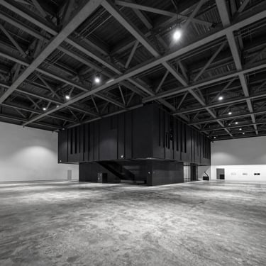 Architectural interior of a massive modern exhibition hall in Jakarta, dramatic high-contrast lighting, cool industrial steel beams, expansive concrete floor, sharp editorial composition.