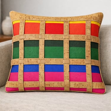 Handmade rainbow decorative pillow with unique cork lattice overlay on a modern beige sofa.