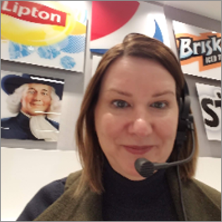 Linda Michael wearing a production headset while directing show flow at a PepsiCo ERG AOP event.