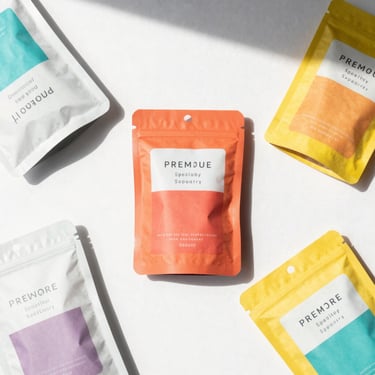 Top-down flat lay of premium specialty retail items and packaged goods, bright high-key retail photography, clean natural daylight, crisp shadows