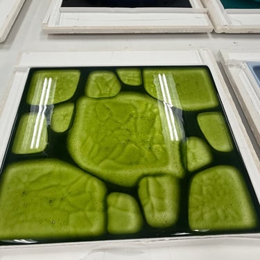 Green organic shapes in table top with dichroic glass