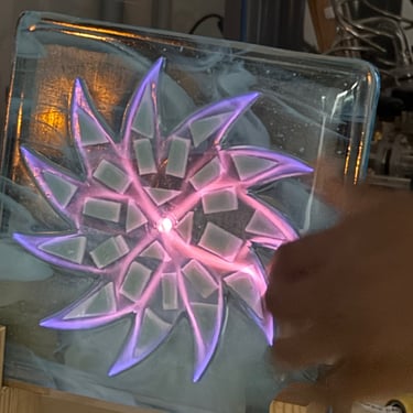 Pink neon gas in closed whirl fused glass container