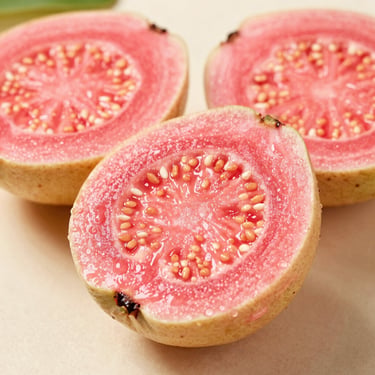 Macro shot of pink guava halves on a neutral surface, soft natural light, vibrant pink interior, sharp focus.