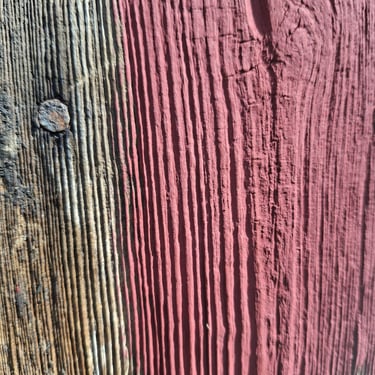 One coat of breathable Barn Red paint applied on rough sawn wood with visible natural grain and boiled linseed oil.