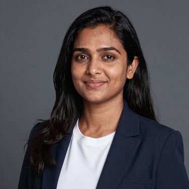 Smiling woman holding a skincare product with glowing skin in a cozy home setting