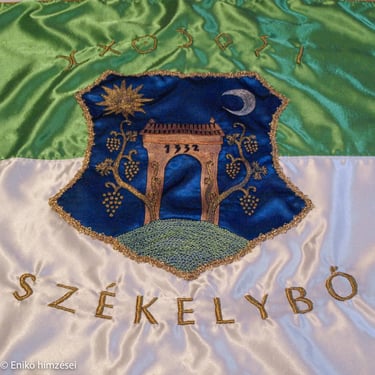 Székelybő település hímzett címere fehér és zöld selyem alapon.