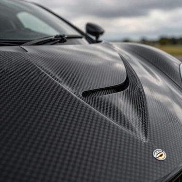 Macro detail of the carbon fiber weave on an elite hypercar body, natural dramatic overcast light.