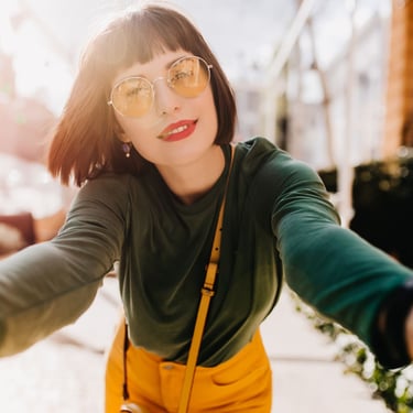 Mujer viste elegante viste suéter verde frente a la cámara selfie moda internacional