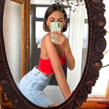 Mujer viste elegante posa frente al espejo jeans y top rojo moda internacional México