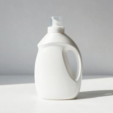 Minimalist white bottle of premium laundry detergent on a clean surface, bright daylight, soft shadows