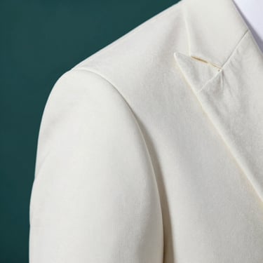 Detailed close-up of a tailored blazer shoulder seam, crisp white fabric, elegant minimalist aesthetic