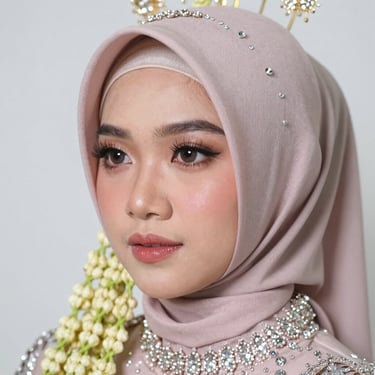 Close-up of a woman elegantly wearing a maroon handmade headscarf with gold accents.