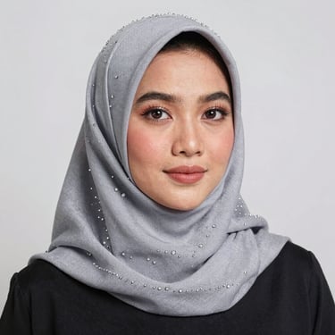 Portrait of a smiling woman in a minimalist setting, showcasing a cream-colored headscarf.