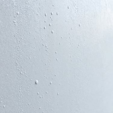 Water droplets beading on a freshly waterproofed wall surface, close-up, showing protective layer, Ahmedabad.