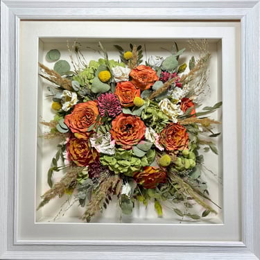 a bold, bright Birdseye view preserved wedding bouquet in a frame