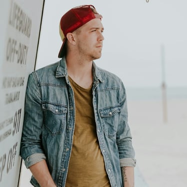 a man in a denim jacket and a red bandanna