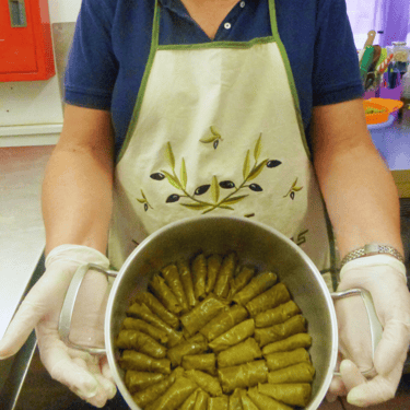 Cooking lesson in Crete, making dolmadakia in a large pot