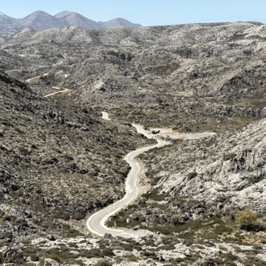 Scenic mountain road winding through the misty highlands of Crete
