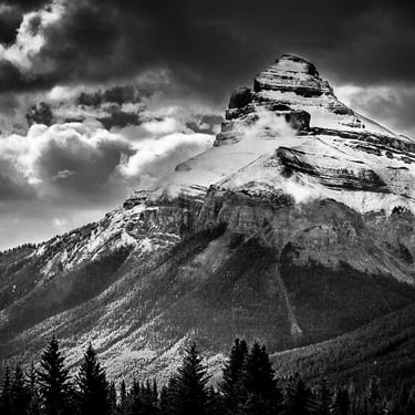 Charity Mountain in the Canadian Rocky Mountains, showcasing it's rugged snow covering and a dramtic sky