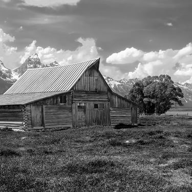 Historic T.A. Moulton Barn in Grand Teton National Park, with dramatic mountain backdrop and rustic western landscape