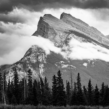 Mount Rundle in Banff National Park, parktially shrouded in clouds, highlighting it's dramatic peaks