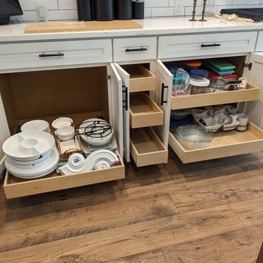 Kitchen cabinet pull-outs in three cabinets, all extended to show easy accessibility to stored contents.