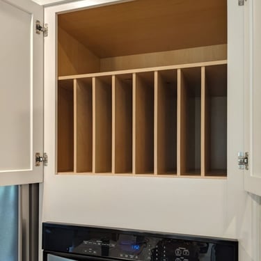 A tray divider installed in a cabinet above a built in oven.