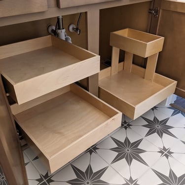 Pull out cabinet drawers designed to maximize storage in a bathroom vanity.