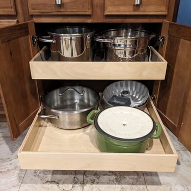 Kitchen cupboard pullouts holding pots and pans.
