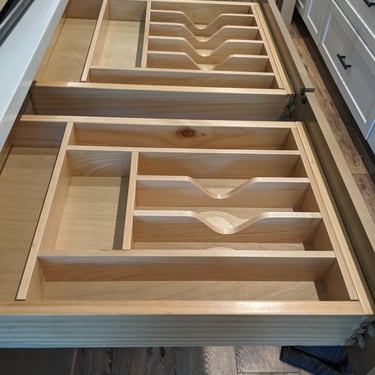Utensil divider inserts inside of open kitchen drawers.