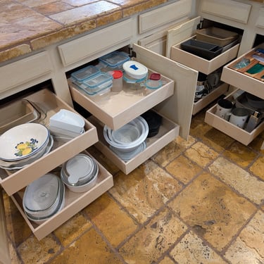 Eight kitchen cabinet pull-out shelves are extended for easy access to dishes, bake ware and  cooking items.