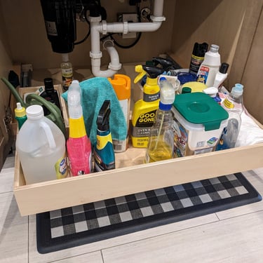 Roll out shelving under a kitchen sink makes all the stored contents easily accessible.