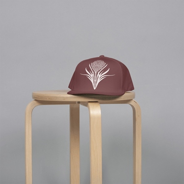 a brown hat with a rice flower on it sitting on a stool