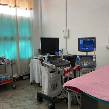a hospital room with a bed and a ultrasound machine