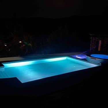 Vista nocturna con luces de la piscina de la villa presidencial Constanza