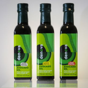 three bottles of Denovoa Avocado oil on a table
