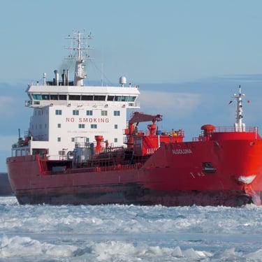 A view of tanker ship Algoluna from the front right side, looking aft. The ship is surrounded by ice covered water.