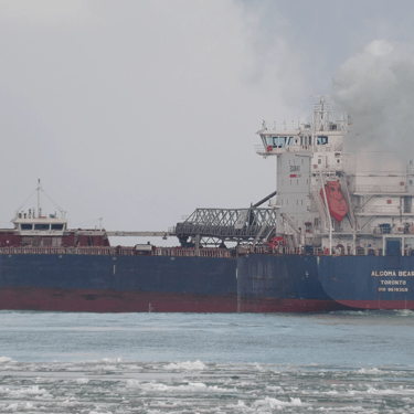Algoma Bear port side stern view on icy water, with heavy exhaust steam around her pilothouse.