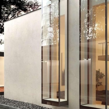 Fachada arquitectónica revestida en madera y vidrio, con cerramientos móviles para regular luz y privacidad