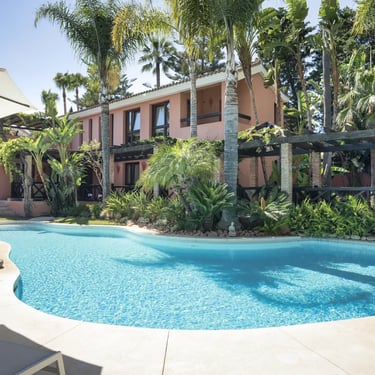 Saltwater swimming pool surrounded by tropical gardens at a private Marbella villa