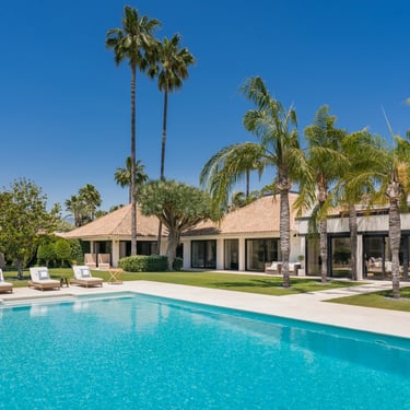 Daytime pool terrace with loungers and tropical garden