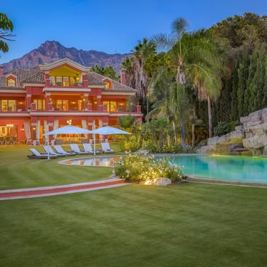 Beachfront estate illuminated at sunset overlooking the gardens