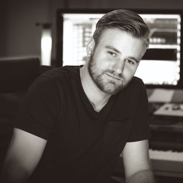 a man with a beard and a beard sitting in front of a piano. He is Ben Reno of Majestic Ape Studio.