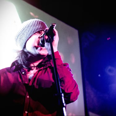 a man in a beanie hat and a microphone