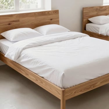Bright clean commercial photography of a modern wooden double bed frame with clean white sheets in a bright showroom, natural daylight, crisp details, 35mm lens.
