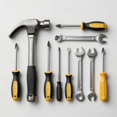 Overhead flat-lay of repair tools on a clean white surface — hammer, screwdrivers, wrench — arranged neatly, studio daylight